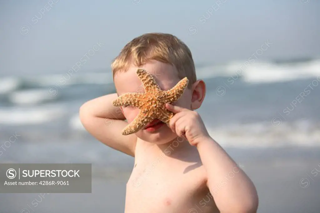 Young boy with starfish over face