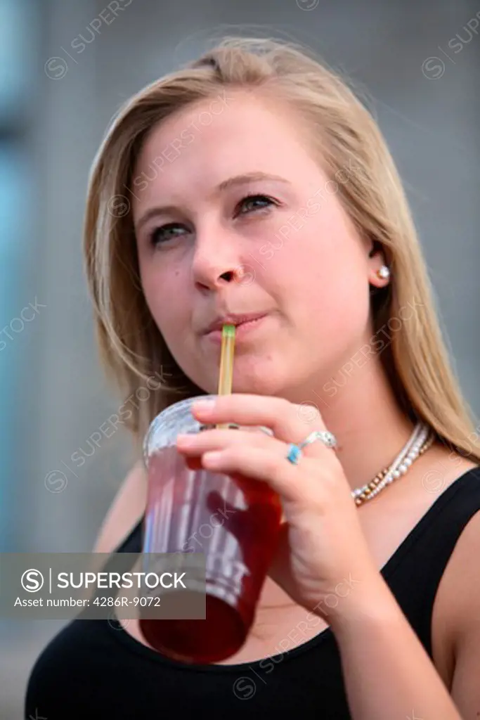 Young woman drinking iced tea