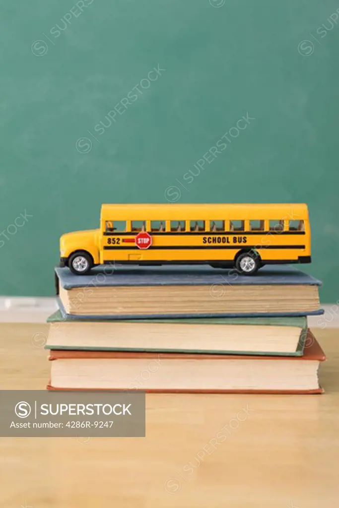School education still life of toy school bus on stack of books