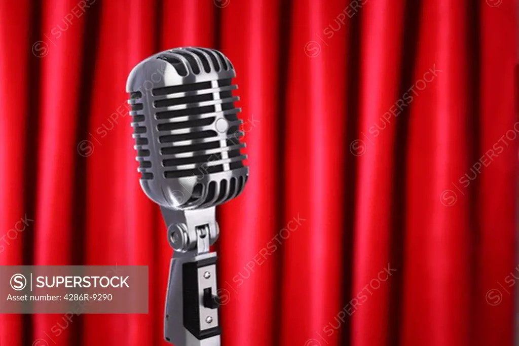 Classic retro microphone with red curtain background