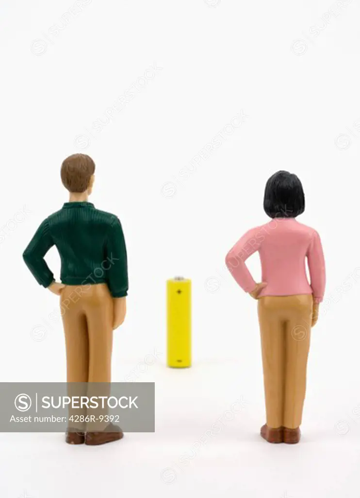 Man and woman figurines look at a battery.