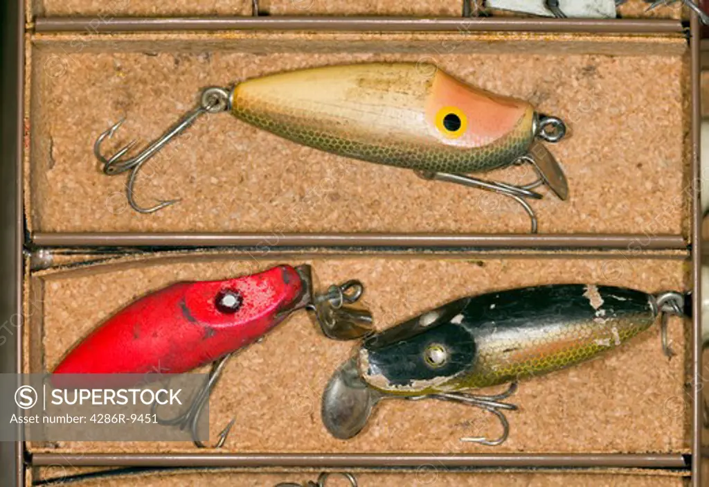 Still life of vintage fishing lures in a tackle box.