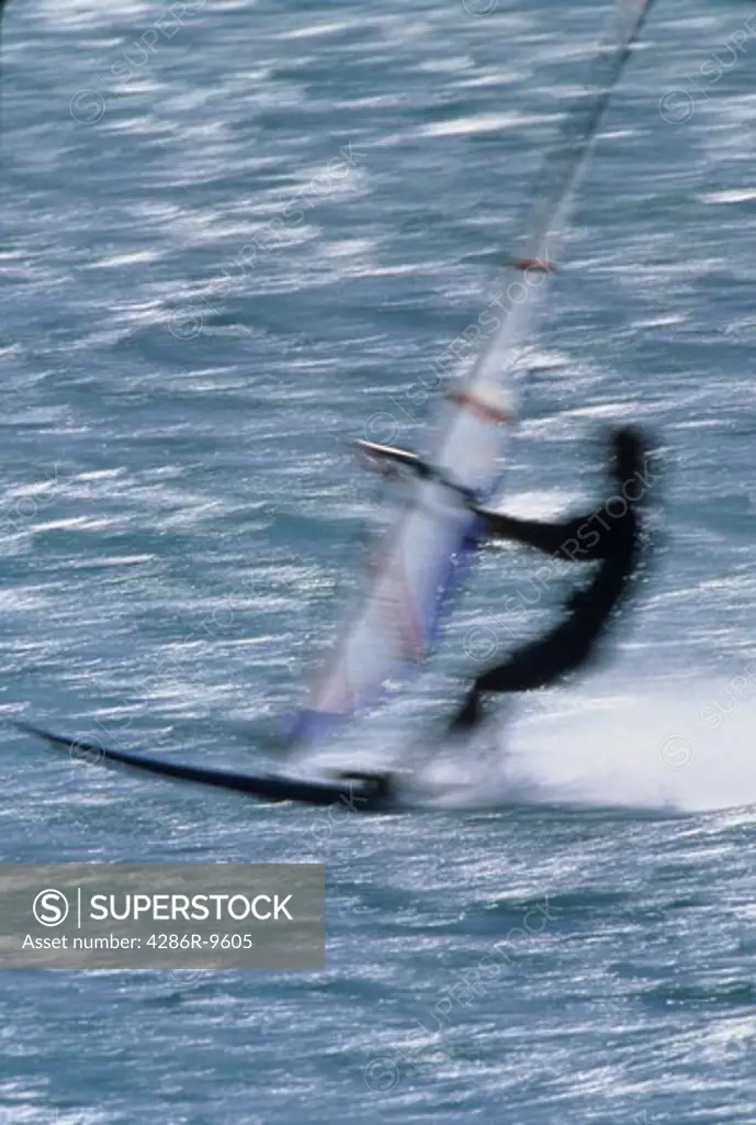 Blurred, silhouette image of a windsurfer.