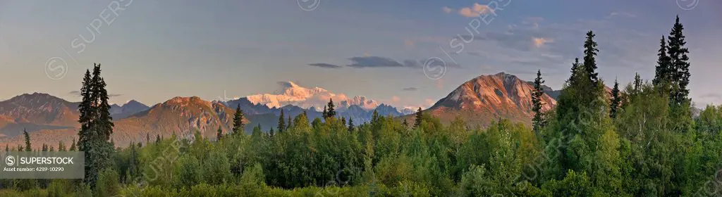 Sunrise alpenglow lights up Mount McKinley and the Moose´s Tooth, as seen from the Veterans Memorial in Denali State Park, Alaska, Summer