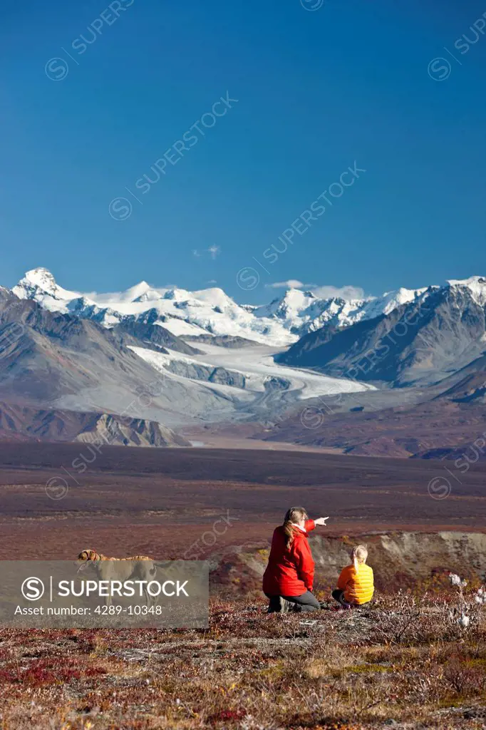 Mother and daughter enjoy the view of Summit Lake and the Alaska Range from the Denali Highway near Paxson, Interior Alaska, Autumn