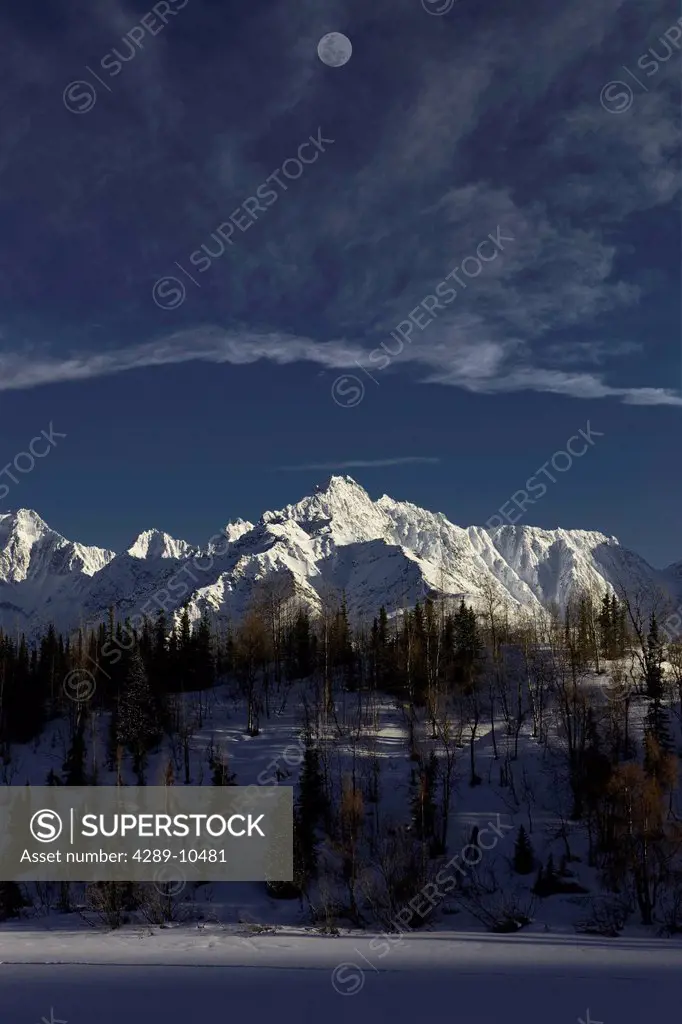 COMPOSITE: Scenic view of a full moon over the Chugach Mountains with Weiner Lake in the foreground, Southcentral Alaska, Winter