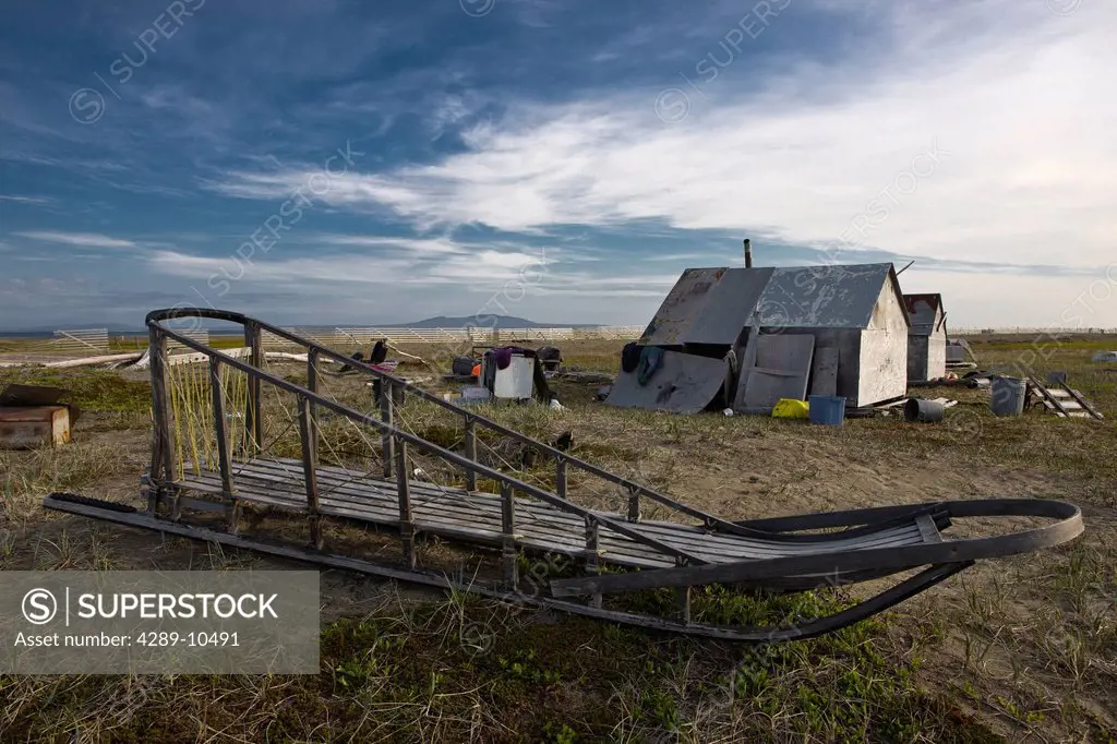 Traditional wooden dog sled and buildings at Summer hunting camp on Shishmaref Island, Arctic Alaska, Summer