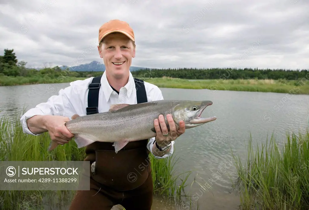 Angler Holding A Red Salmon Caught By Fly Fishing In The Brooks River, Katmai National Park, Alaska.