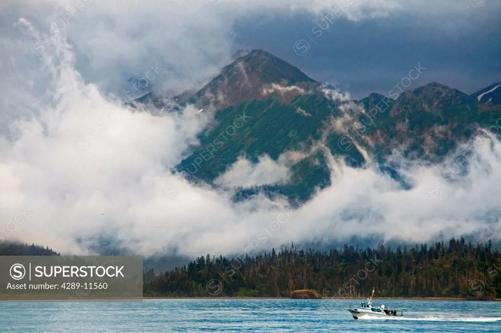 Sport fishing charter boat in Kachemak Bay with the fog enshrouded Kenai Mountains in the background, Kachemak Bay State Marine Park, Southcentral Ala...