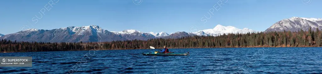 Woman kayaking in Byers Lake with scenic view of Mt. McKinley on a clear sunny day, Denali State Park, Southcentral Alaska, Autumn