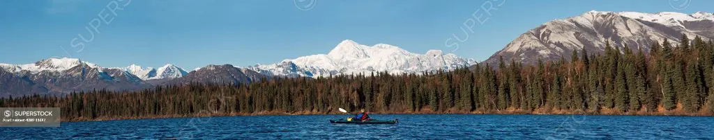 Woman kayaking in Byers Lake with scenic view of Mt. McKinley on a clear sunny day, Denali State Park, Southcentral Alaska, Autumn