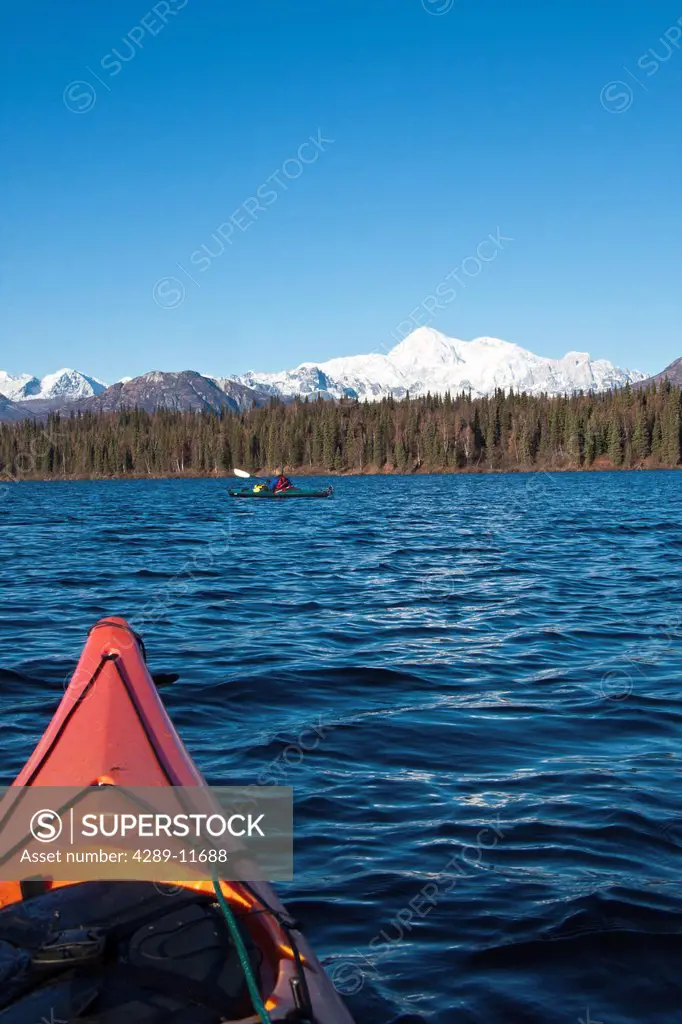 Woman kayaking in Byers Lake as seen from another kayaker´s point of view with scenic view of Mt. McKinley on a clear sunny day, Denali State Park, So...