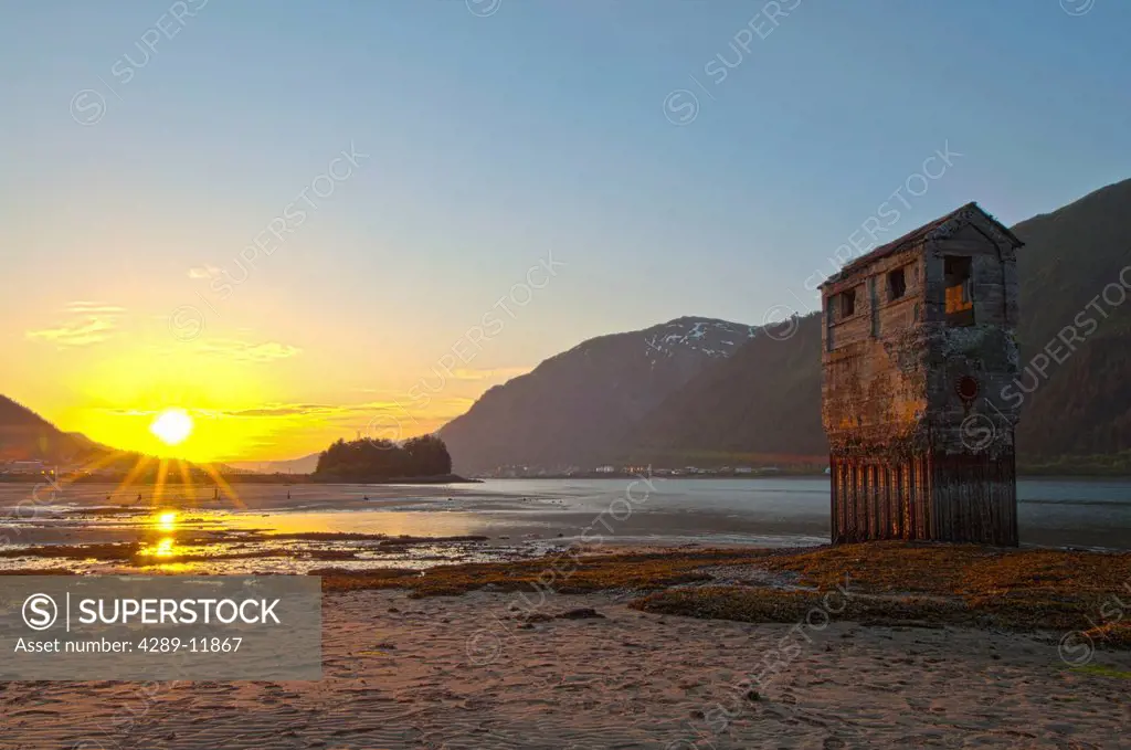 View of an old placer mining operation on the shore of Douglas Island at sunset, across from Juneau, Southeast Alaska, Summer, HDR.