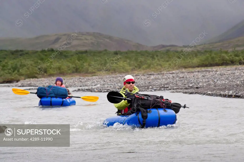 Two people packrafting the Sanctuary River in rainy weather, Denali National Park & Preserve, Alaska Range, Interior Alaska, Summer