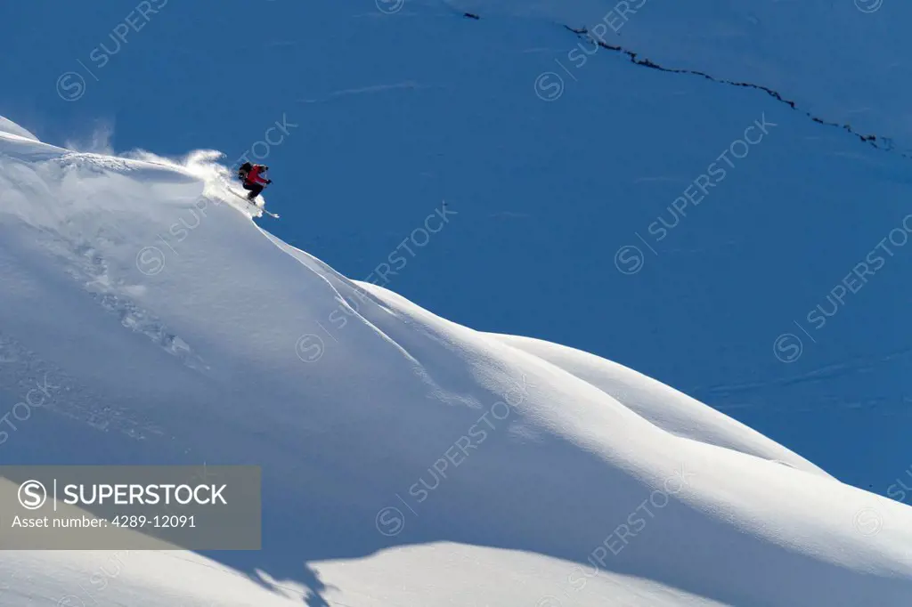 Man backcountry skiing powder snow on the south face of Eddies Ridge, Turnagain Pass, Kenai Mountains, Winter in Southcentral Alaska