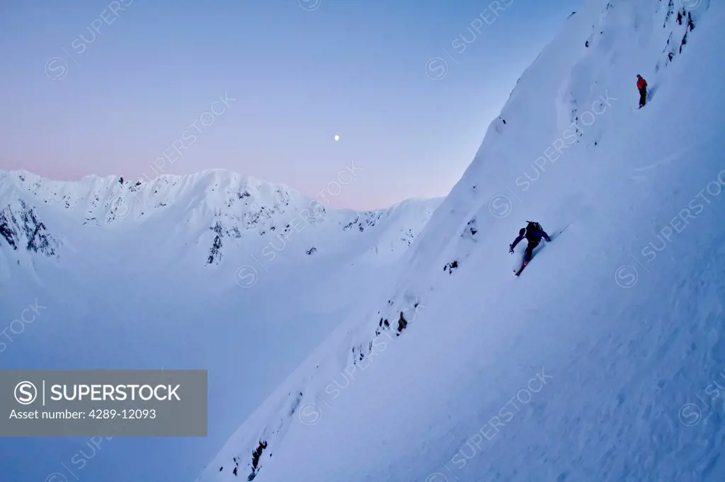Skier and his spotter skiing steep powder on the north side of Kickstep Mountain, Turnagain Pass, Kenai Mountains, Winter in Southcentral Alaska. MR