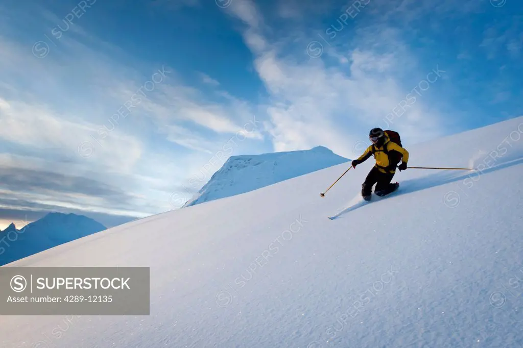 Skier skiing powder snow above Thompson Pass on Girls Mountain near Valdez, Chugach Mountains, Winter in Southcentral Alaska