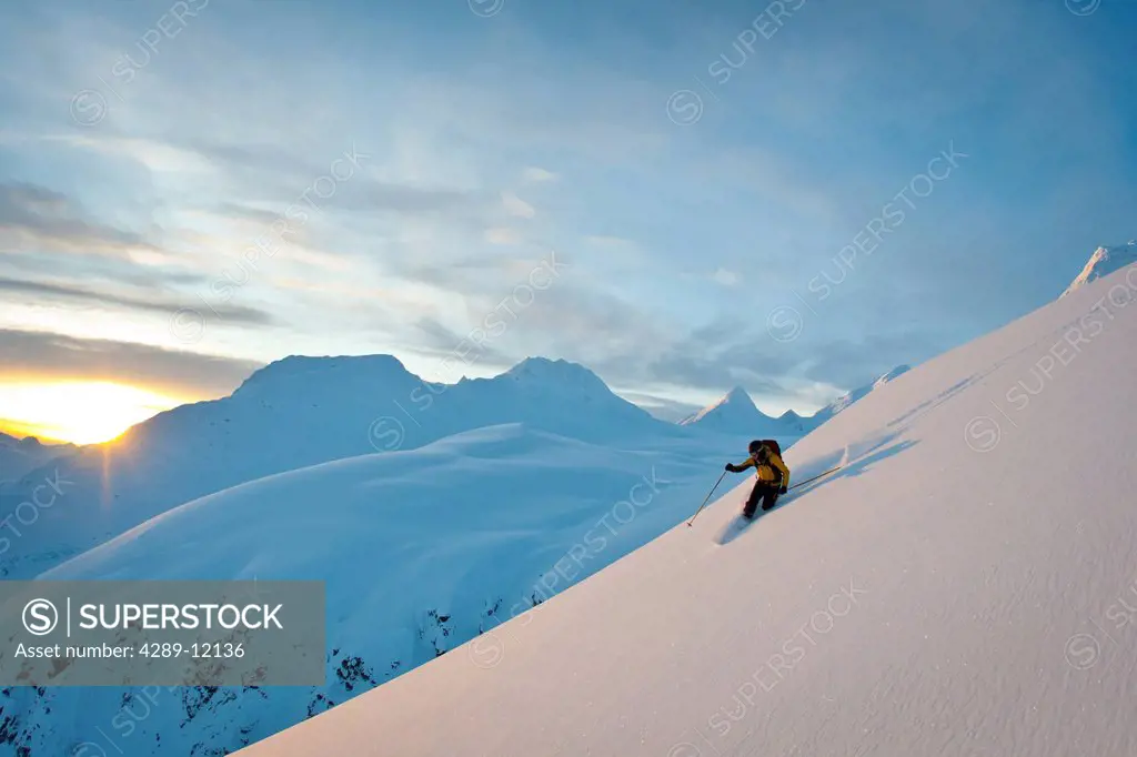 Skier skiing powder snow above Thompson Pass on Girls Mountain near Valdez, Chugach Mountains, Winter in Southcentral Alaska