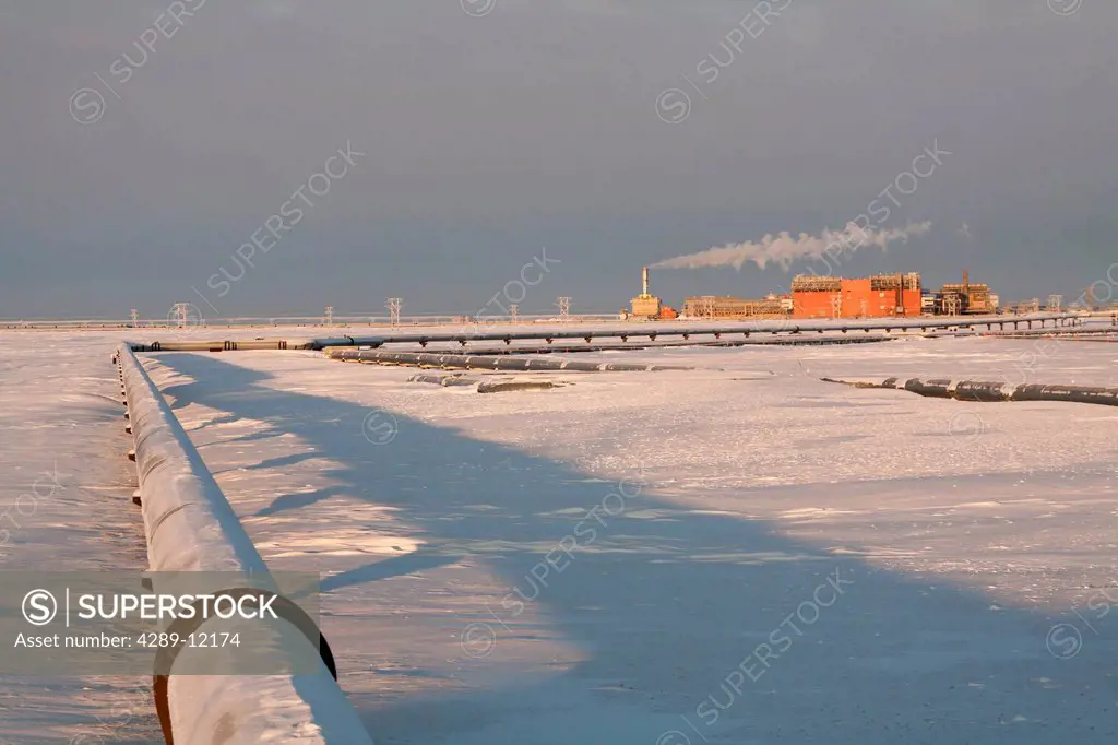Snow covered pipelines and the Central Gas Facility CGF, Prudhoe Bay Oil field, Arctic Alaska, Winter