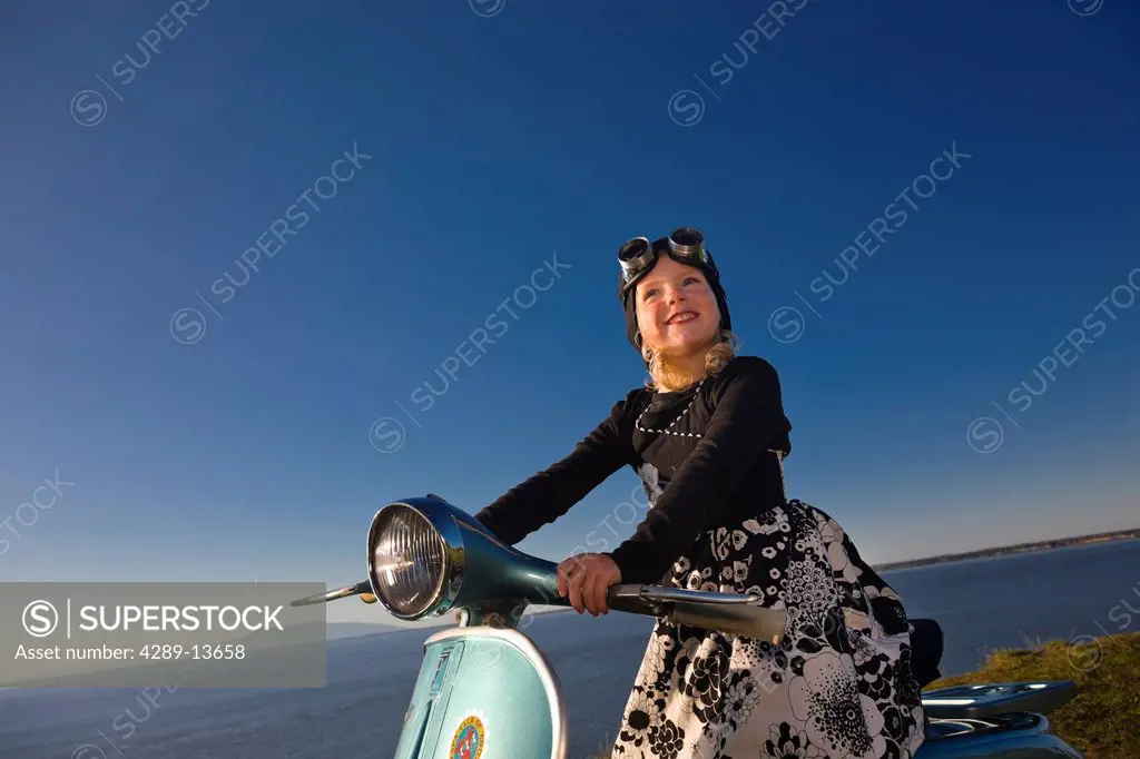 Young girl wearing goggles and sitting on a vintage Vespa, Pt. Woronzof, Cook Inlet, Anchorage, Southcentral Alaska, Summer