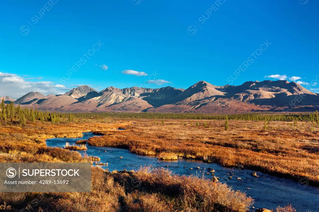 Scenic mountain landscape with a creek in the foreground seen from the Denali Highway, Southcentral Alaska, Autumn