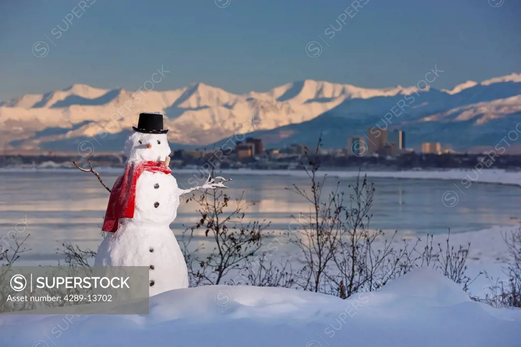 Scenic view of Chugach Mountains, Anchorage skyline, and Cook Inlet with a snowman in the foreground, Southcentral Alaska, Winter