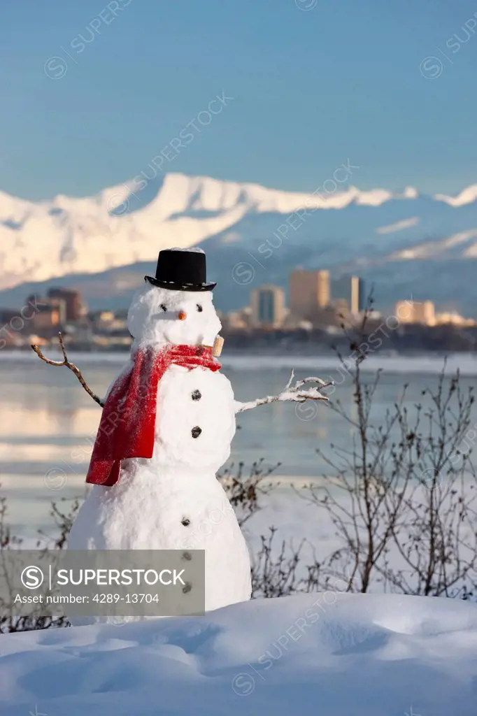 Scenic view of Chugach Mountains, Anchorage skyline, and Cook Inlet with a snowman in the foreground, Southcentral Alaska, Winter