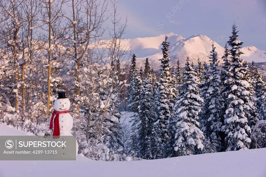 Scenic view of Chugach Mountains with a snowman wearing a scarf and top hat in the foreground, Anchorage, Southcentral Alaska, Winter