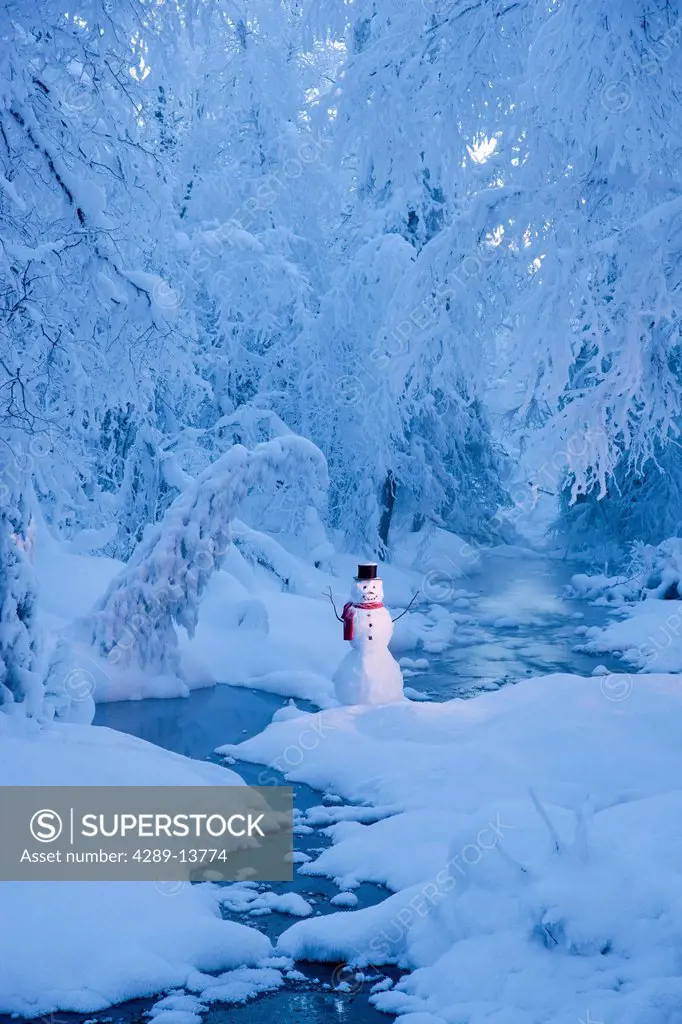 Snowman standing next to a stream with fog and hoar frosted trees in the background, Russian Jack Springs Park, Anchorage, Southcentral Alaska, Winter...