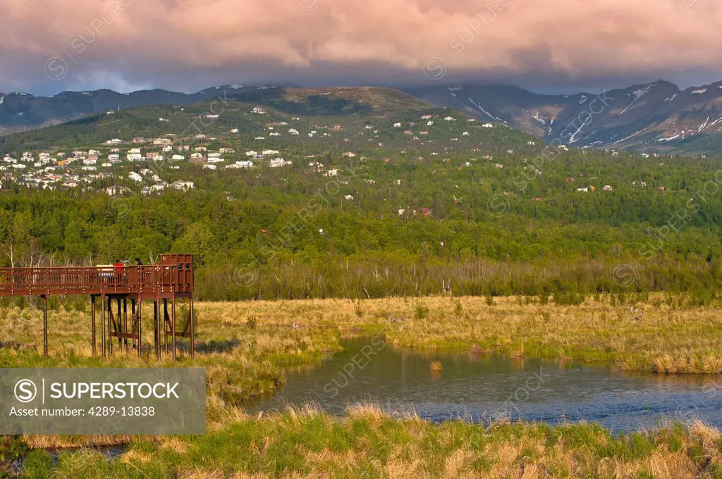 Visitors enjoy the view from the boardwalk at Potter Marsh with the Anchorage hillside in the background, Southcentral Alaska, Spring