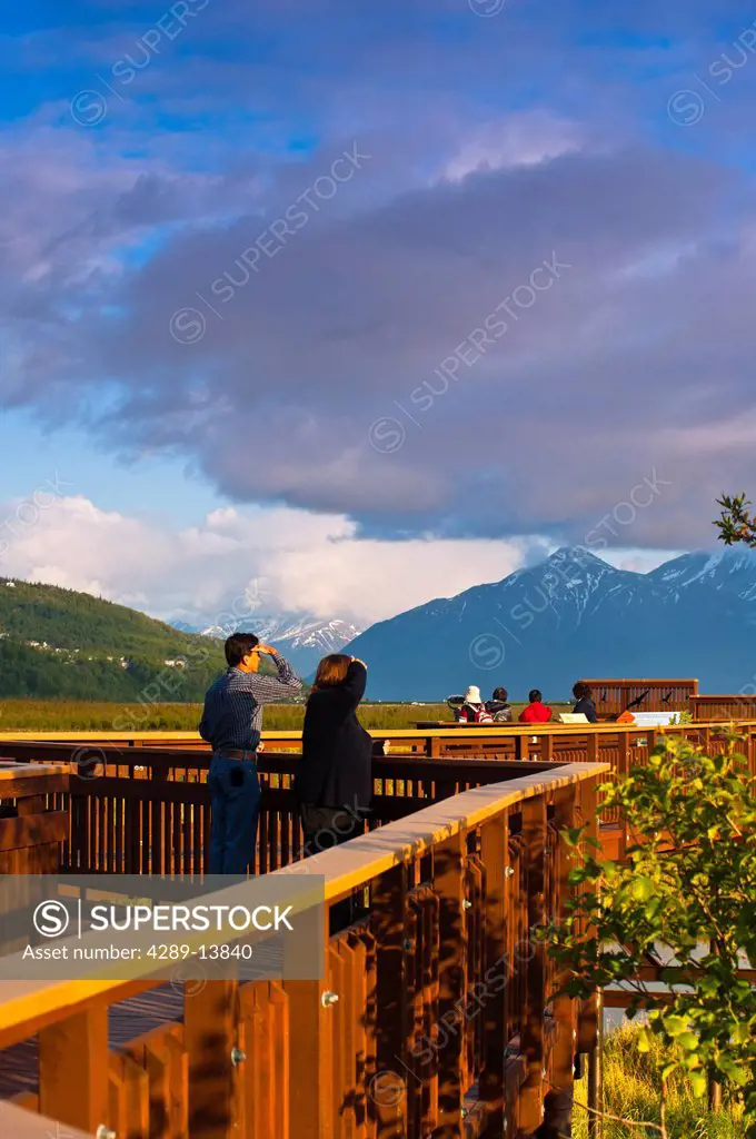 Visitors enjoy the view from the boardwalk at Potter Marsh with the Chugach Mountains in the background, Southcentral Alaska, Spring