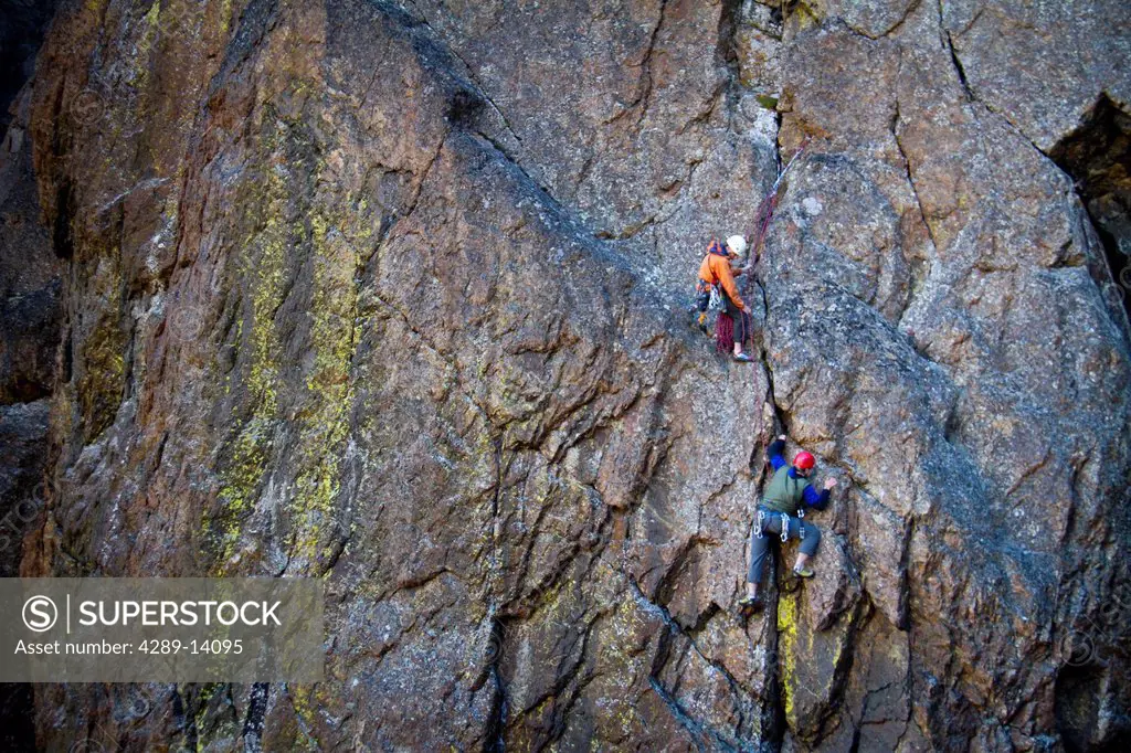 Two men rock climbing a vertical rock wall on The Wedge, Chugach Mountains, Southcentral Alaska, Autumn