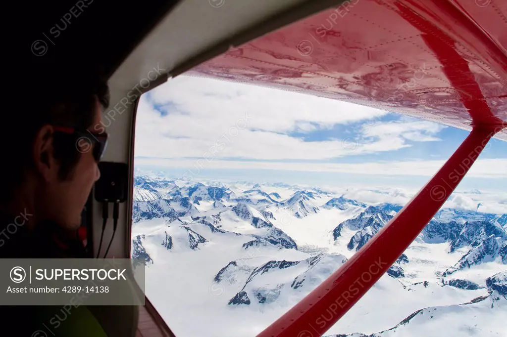 Climber looking out the window from a Turbo Otter at the Wrangell_Saint Elias Mountains, Yukon Territory, Canada, Summer