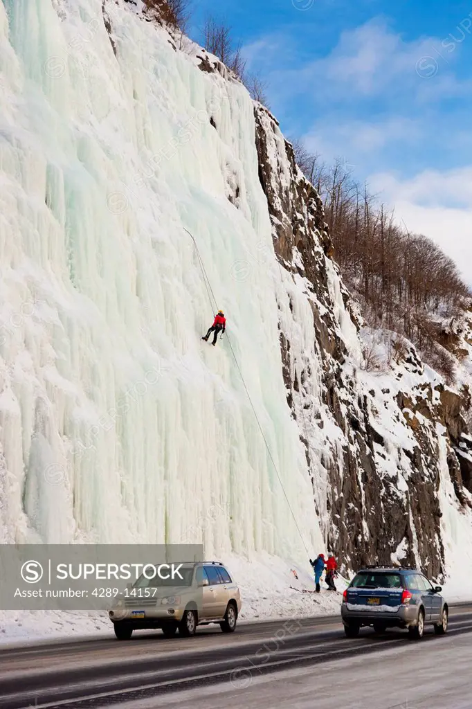 Ice Climbers on a frozen waterfall with traffic passing by on the Seward Highway, Southcentral Alaska, Winter