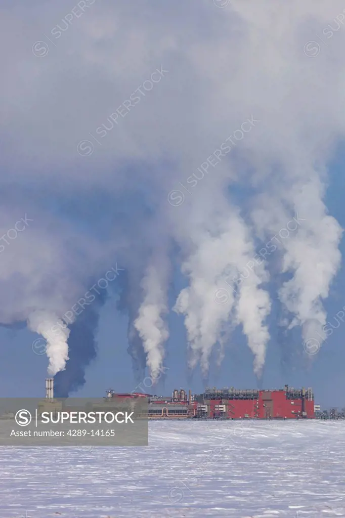 Exhaust flowing out of the Central Gas Facility CGF on a cold winter day in the Prudhoe Bay Oilfield, North Slope, Arctic Alaska