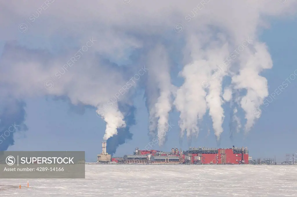 Exhaust flowing out of the Central Gas Facility CGF on a cold winter day in the Prudhoe Bay Oilfield, North Slope, Arctic Alaska