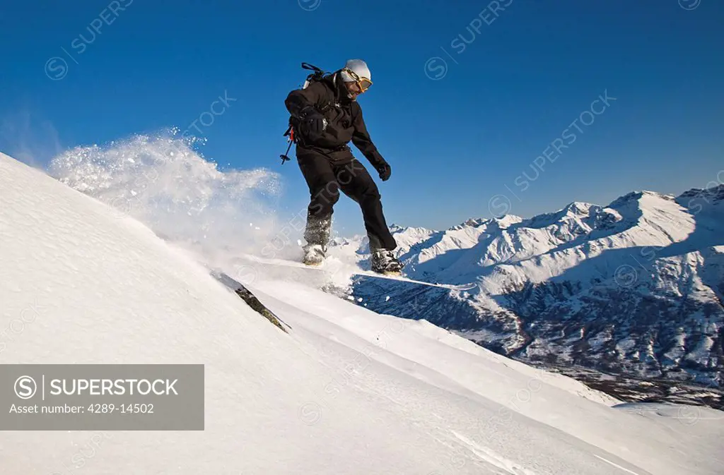 A backcountry snowboarder catches some air while riding in Hatcher Pass, Southcentral, Alaska