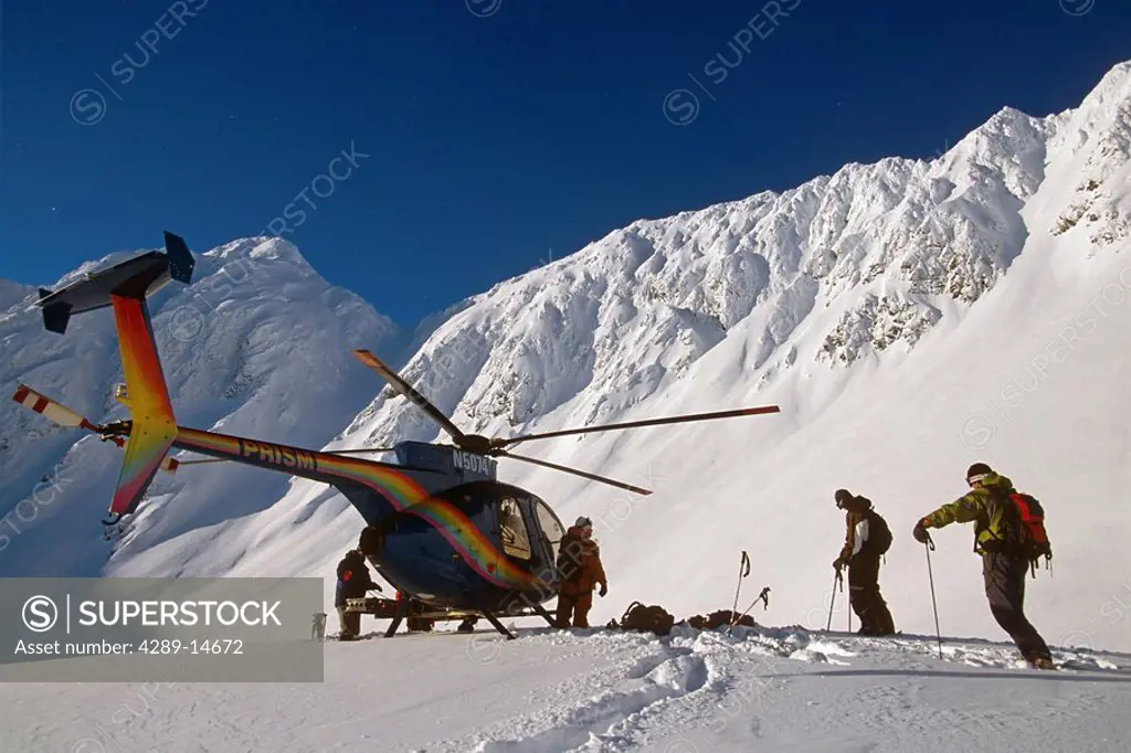 Backcountry extreme skiers unload from helicopter high in Chugach Mountains Southcentral Alaska Winter