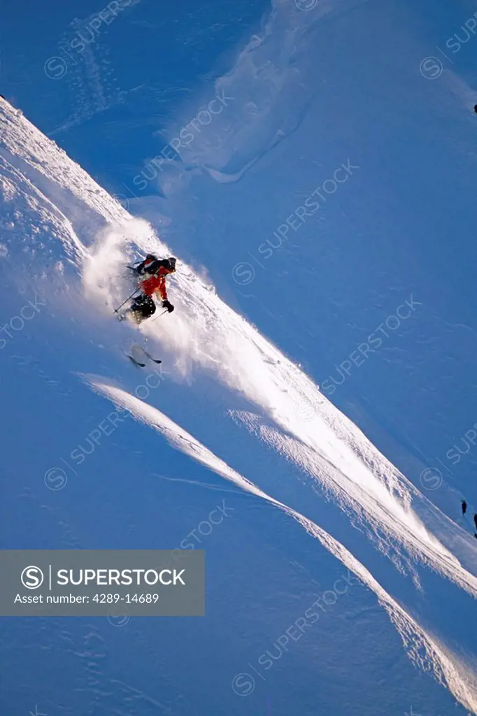 Extreme skier skis down steep snow covered mountain Chugach Mountains Southcentral Alaska Winter