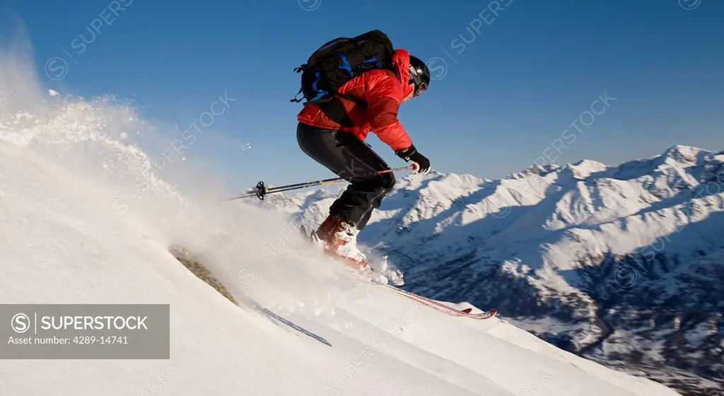 Backcountry skier descends a peak in Hatcher Pass in Southcentral, Alaska during Winter