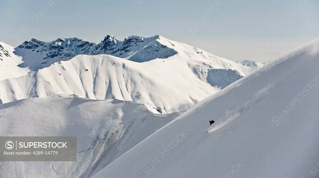 A backcountry skier takes a powder_turn in Hatcher Pass, Alaska