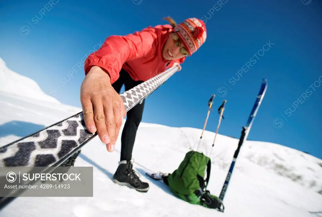 Female skier prepares skis for cross_country skiing in the Center Ridge area of Turnagain Pass of Chugach National Forest, Alaska