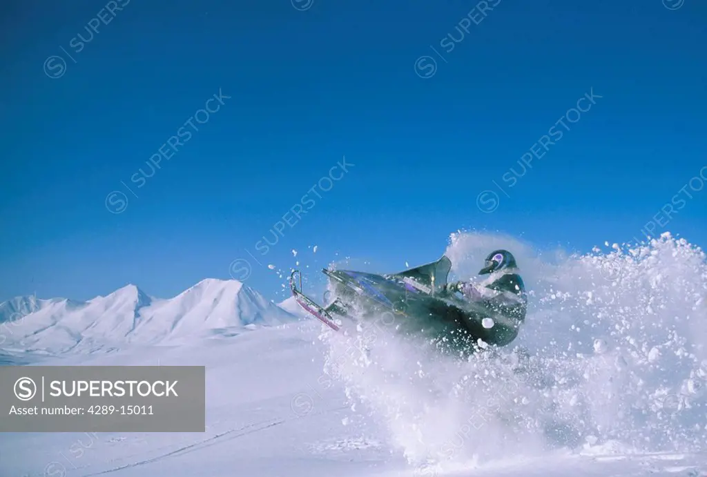 Snowmachine Jumps over Cornice Southeast AK Winter