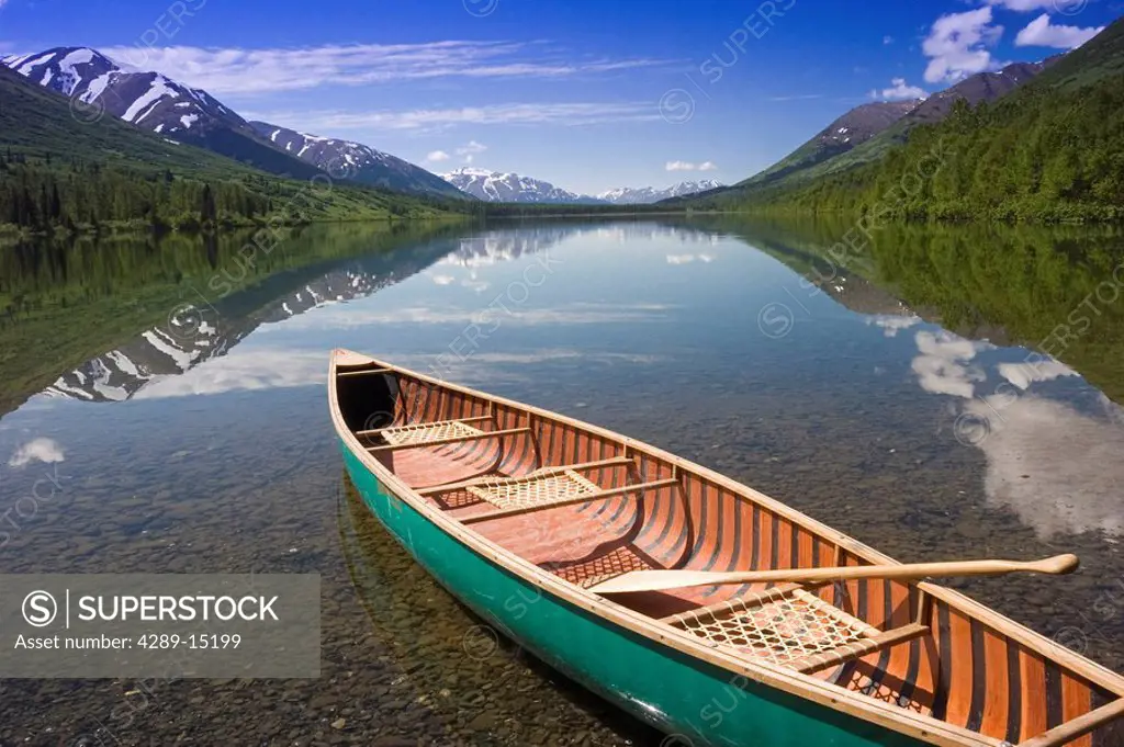 Man Launches Canoe from Shore of Summit Lake KP AK Summer