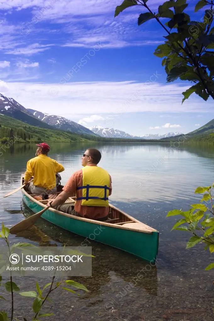 Man Launches Canoe from Shore of Summit Lake KP AK Summer