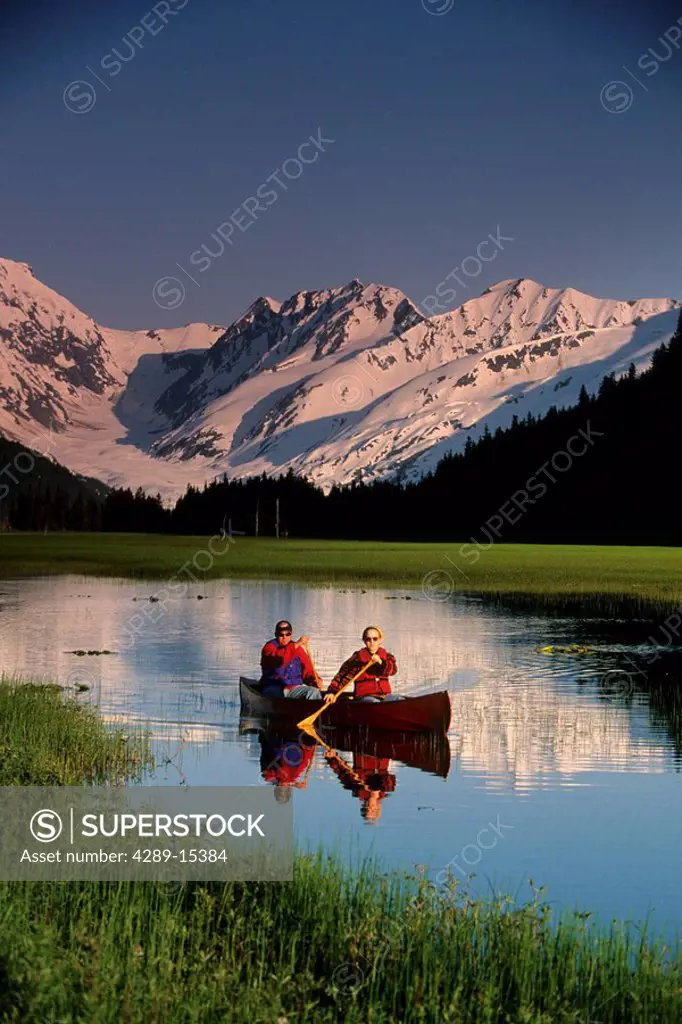 Couple canoeing pond Kenai Peninsula near Portage AK summer scenic