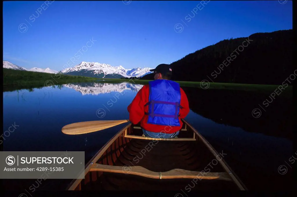 Man canoeing in pond Kenai Peninsula near Portage AK summer scenic