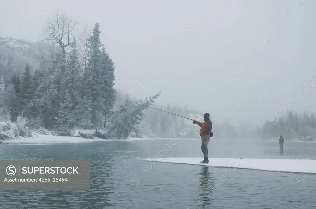 Fly fishermen fish the cold waters of the Kenai River in South Central Alaska during the winter