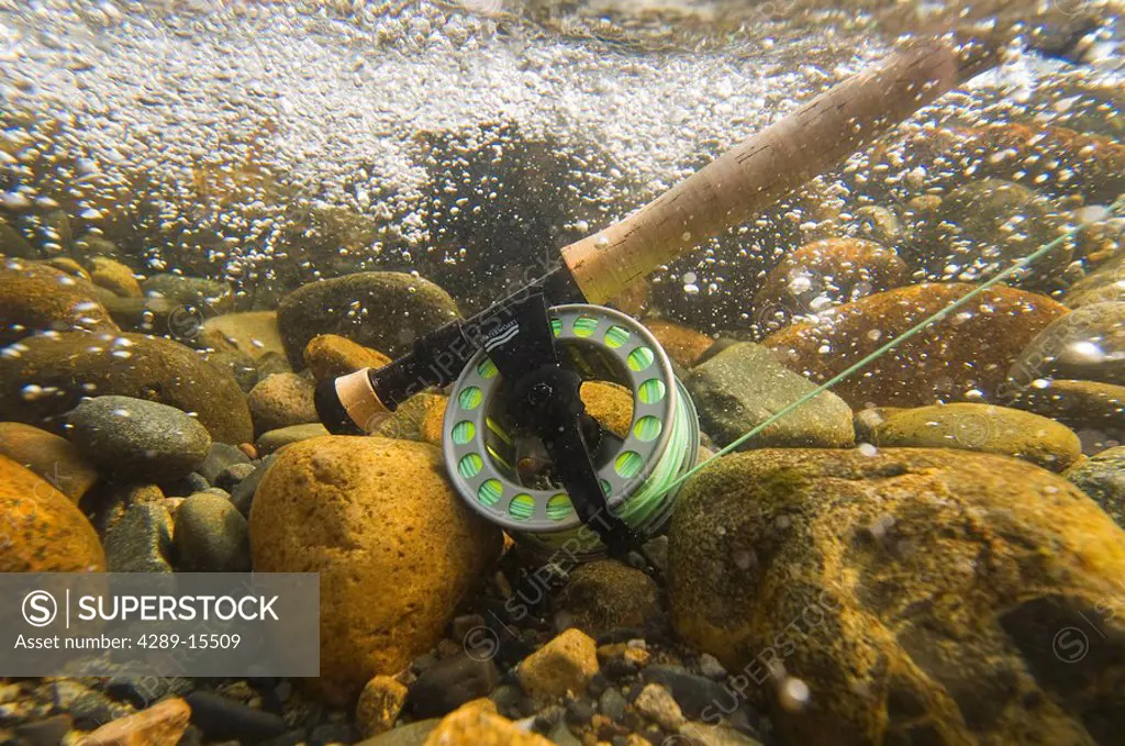 Underwater view of a fly rod and reel in the fast moving water of Montana Creek, Alaska