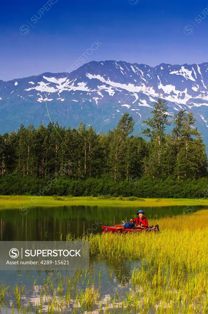 Fly fisherman in a kayak fishing in Portage Valley, Southcentral, Alaska, Summer
